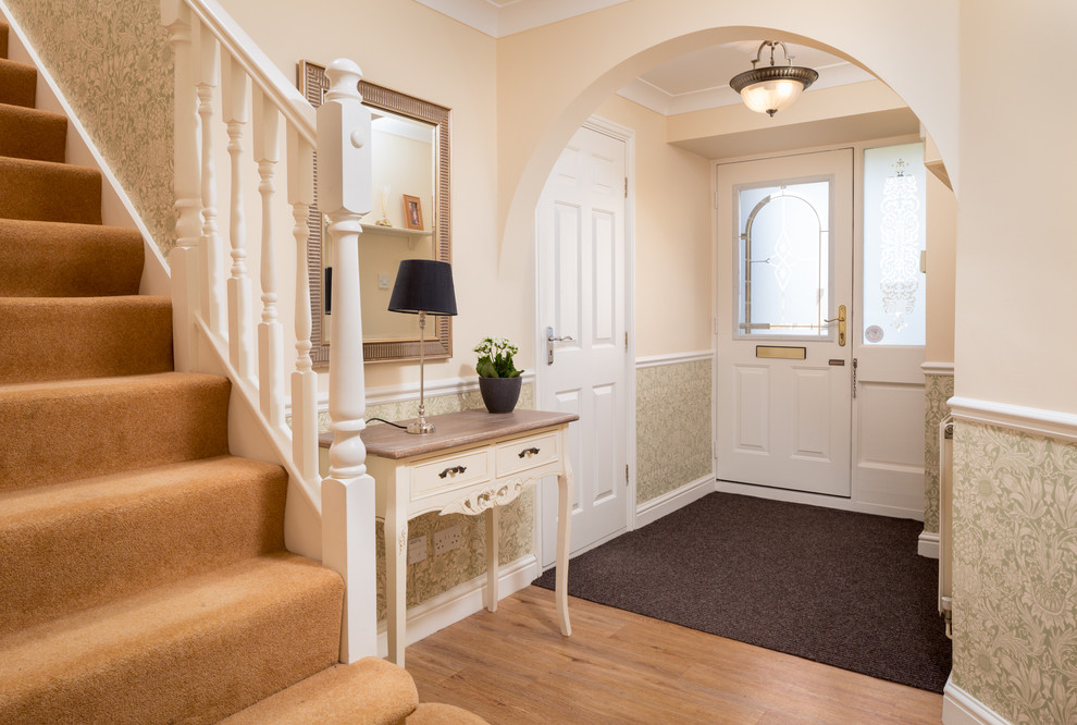 Foto de hall tradicional de tamaño medio con paredes beige, suelo de madera clara, puerta simple y puerta blanca