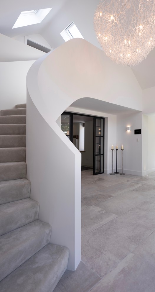 This is an example of a large contemporary hallway in Cheshire with white walls, ceramic flooring, a single front door, a light wood front door and white floors.