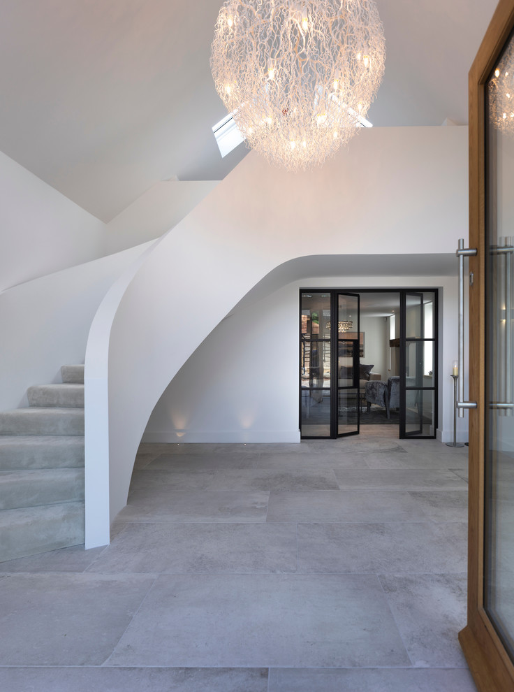 Idée de décoration pour une grande entrée design avec un couloir, un mur blanc, un sol en carrelage de céramique, une porte simple, une porte en bois clair et un sol blanc.