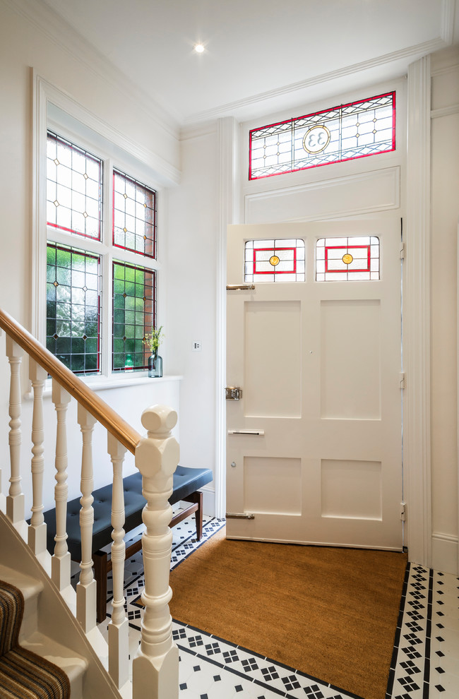 Inspiration för klassiska hallar, med vita väggar, klinkergolv i keramik, en enkeldörr, en vit dörr och flerfärgat golv