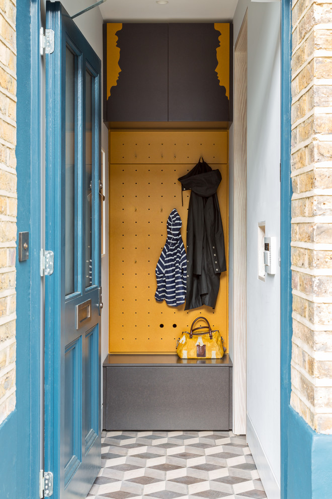 Inredning av ett modernt litet kapprum, med gula väggar, en enkeldörr och en blå dörr