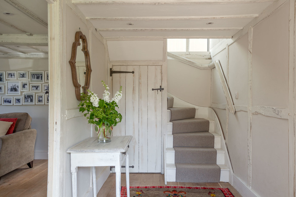 Ejemplo de hall campestre pequeño con paredes blancas, suelo de madera clara y suelo beige