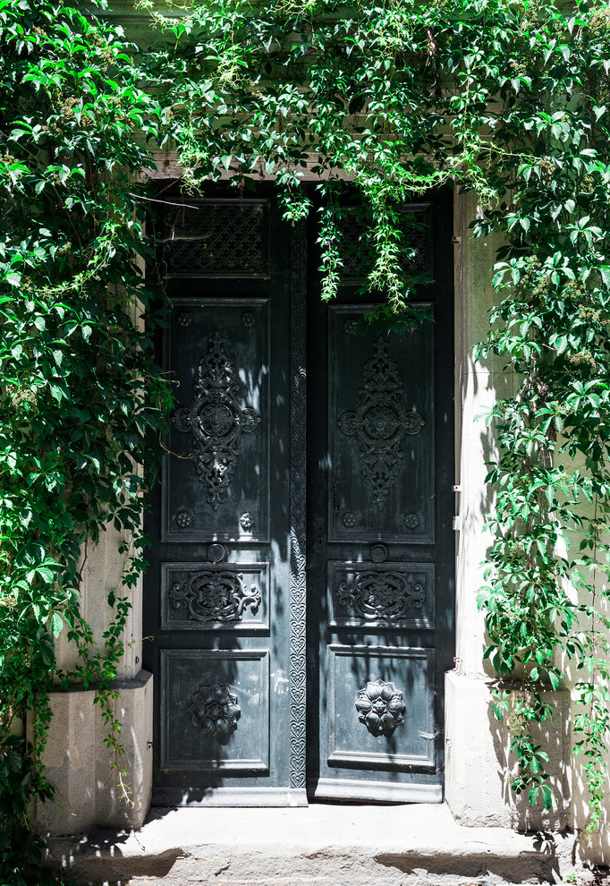 Réalisation d'une grande entrée tradition avec une porte double, un mur beige et une porte verte.