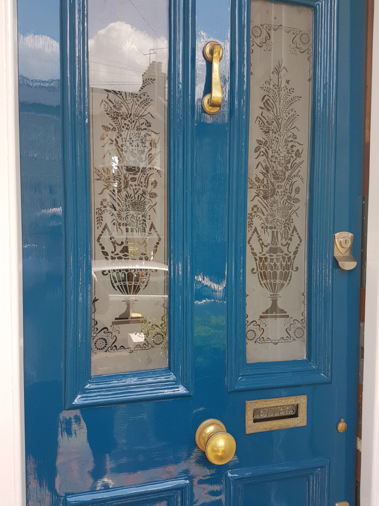 Modelo de puerta principal clásica extra grande con paredes blancas, suelo de baldosas de cerámica, puerta simple, puerta azul, suelo multicolor, bandeja y ladrillo