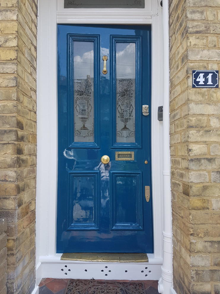 Idee per un'ampia porta d'ingresso tradizionale con pareti bianche, pavimento con piastrelle in ceramica, una porta singola, una porta blu, pavimento multicolore, soffitto ribassato e pareti in mattoni