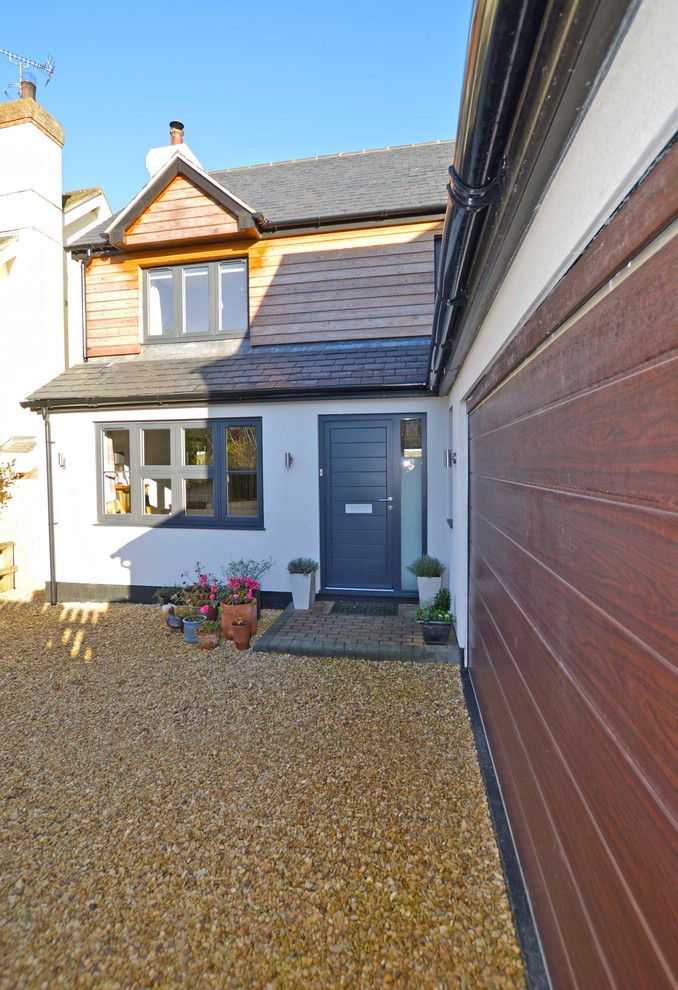 Photo of a medium sized contemporary front door in Berkshire with white walls, a single front door and a dark wood front door.