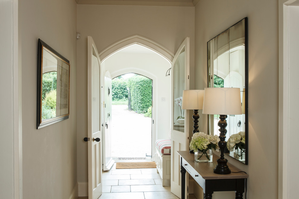 Imagen de entrada clásica con suelo de piedra caliza, puerta simple y puerta blanca