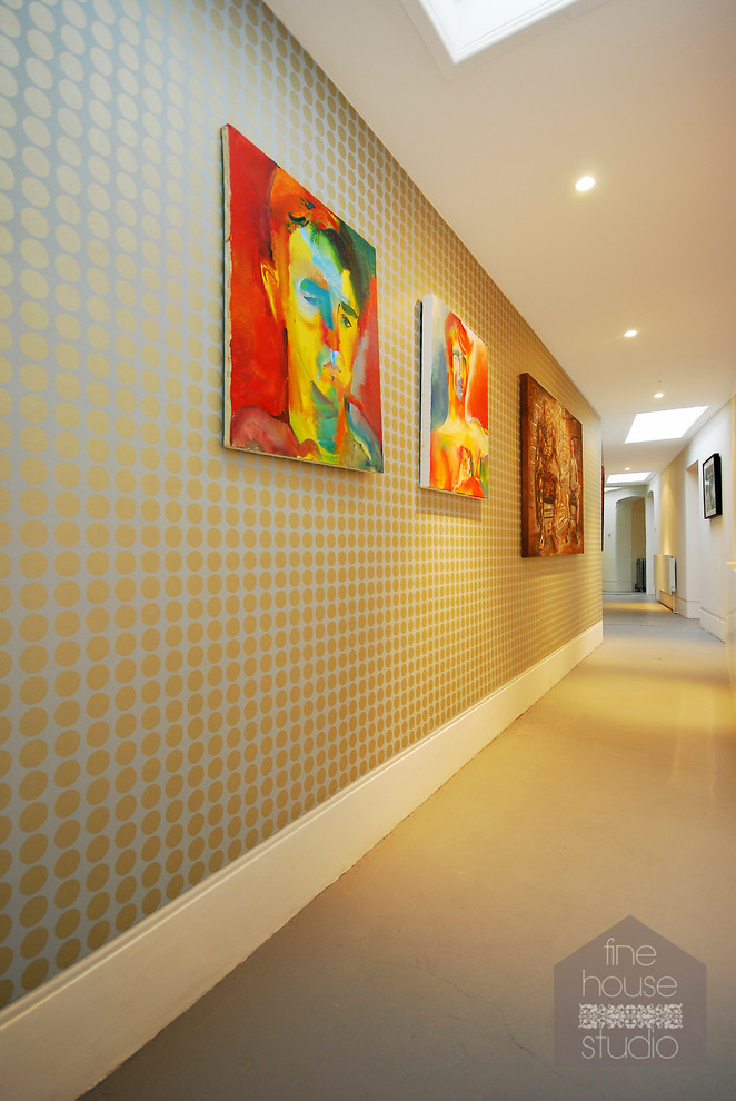 Aménagement d'une très grande entrée contemporaine avec un couloir, mur métallisé et sol en béton ciré.