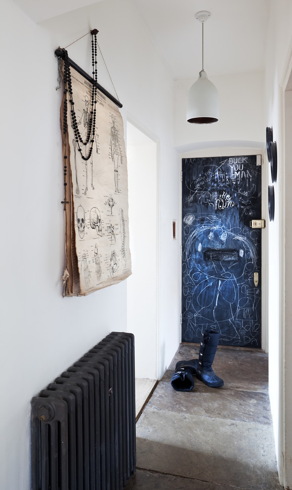 Immagine di un piccolo corridoio boho chic con pareti bianche e pavimento in cemento