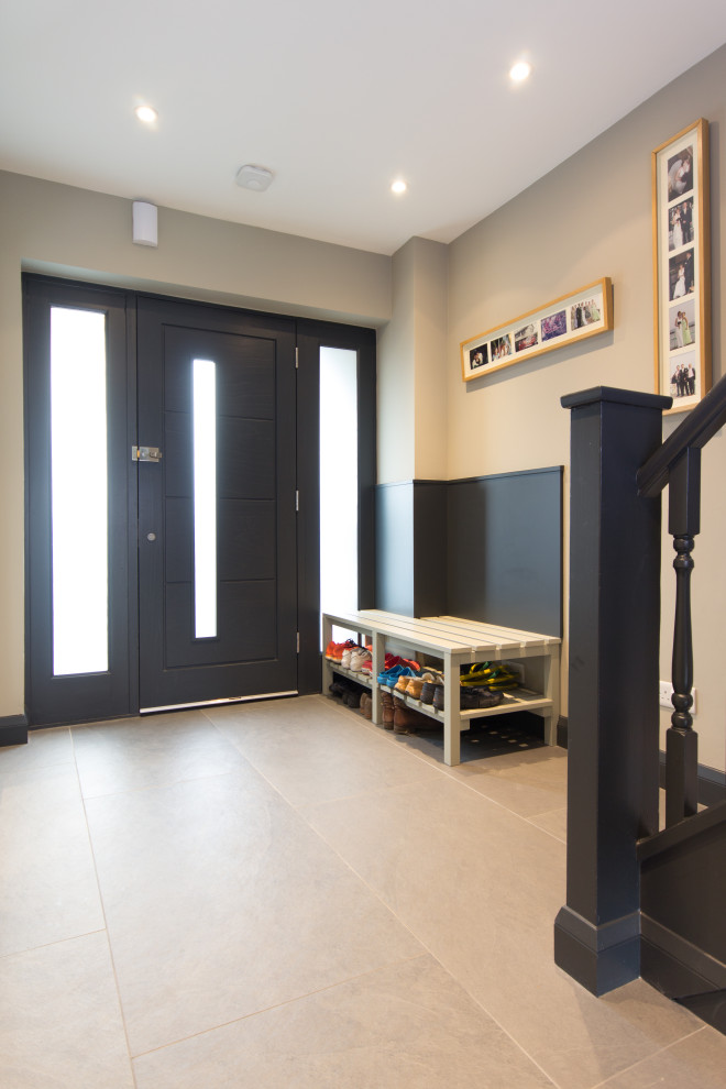 This is an example of a small contemporary hallway in London with grey walls, porcelain flooring, a single front door, a grey front door and grey floors.