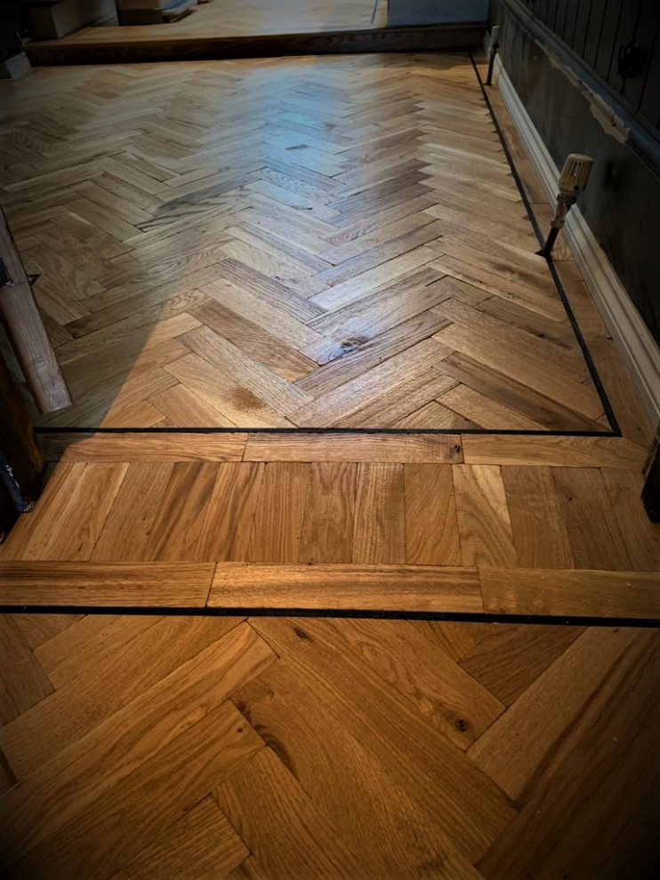 Example of a large classic medium tone wood floor and brown floor entryway design in Hertfordshire