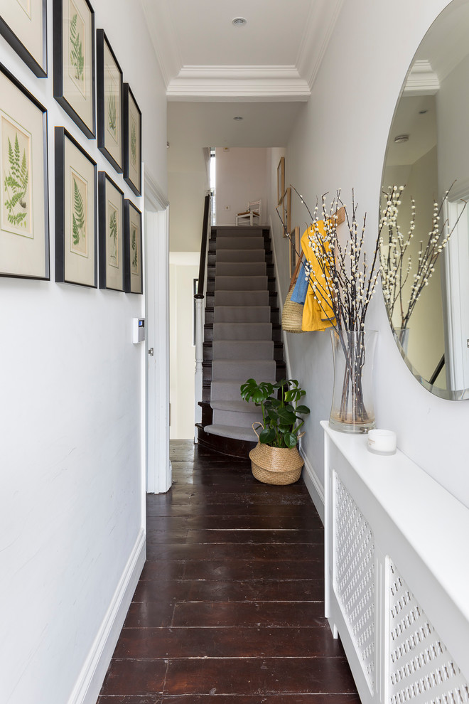 Idee per un piccolo corridoio classico con parquet scuro, una porta singola, pavimento marrone e pareti bianche