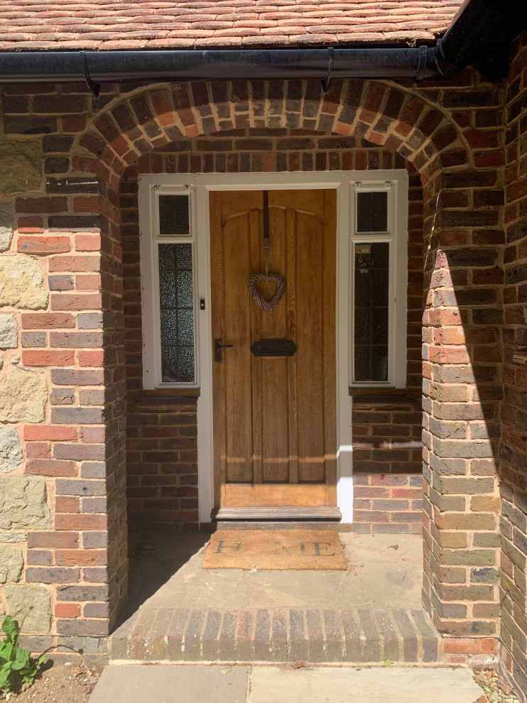 Kleine Landhaus Haustür mit Kalkstein, Einzeltür und hellbrauner Holzhaustür in Sussex
