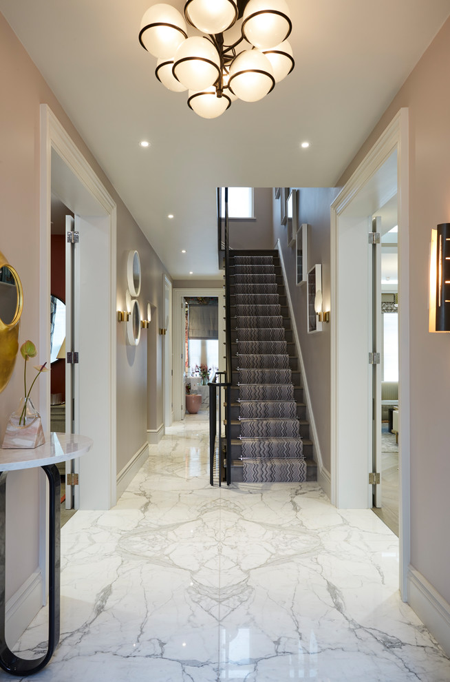 Design ideas for a contemporary entrance in London with pink walls, marble flooring and white floors.
