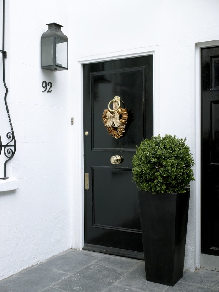 На фото: входная дверь в классическом стиле с черной входной дверью с