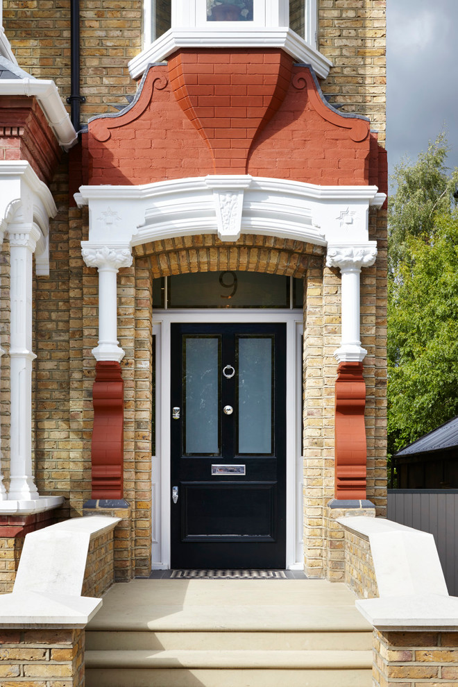 ロンドンにあるヴィクトリアン調のおしゃれな玄関ドア (黒いドア) の写真