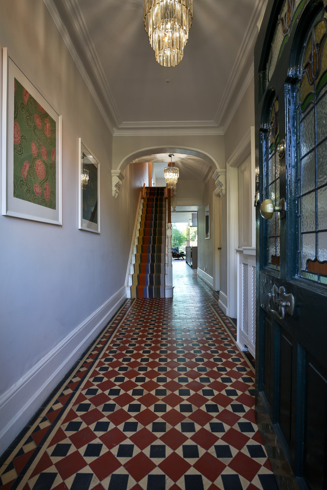 オックスフォードシャーにある広いヴィクトリアン調のおしゃれな玄関ホール (ベージュの壁、セラミックタイルの床、青いドア、マルチカラーの床) の写真