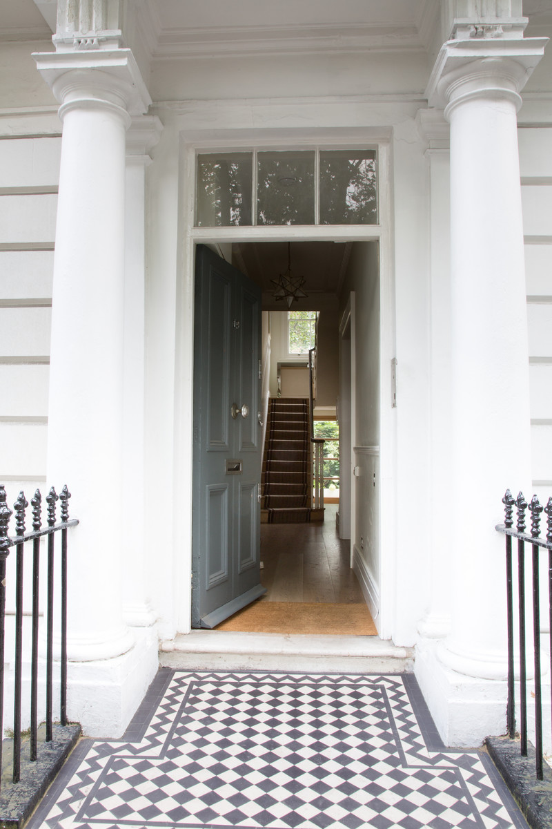 На фото: большая прихожая в викторианском стиле с одностворчатой входной дверью и серой входной дверью с