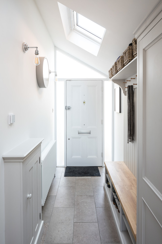 他の地域にあるお手頃価格の小さなコンテンポラリースタイルのおしゃれな玄関ロビー (白い壁、磁器タイルの床、白いドア、グレーの床) の写真