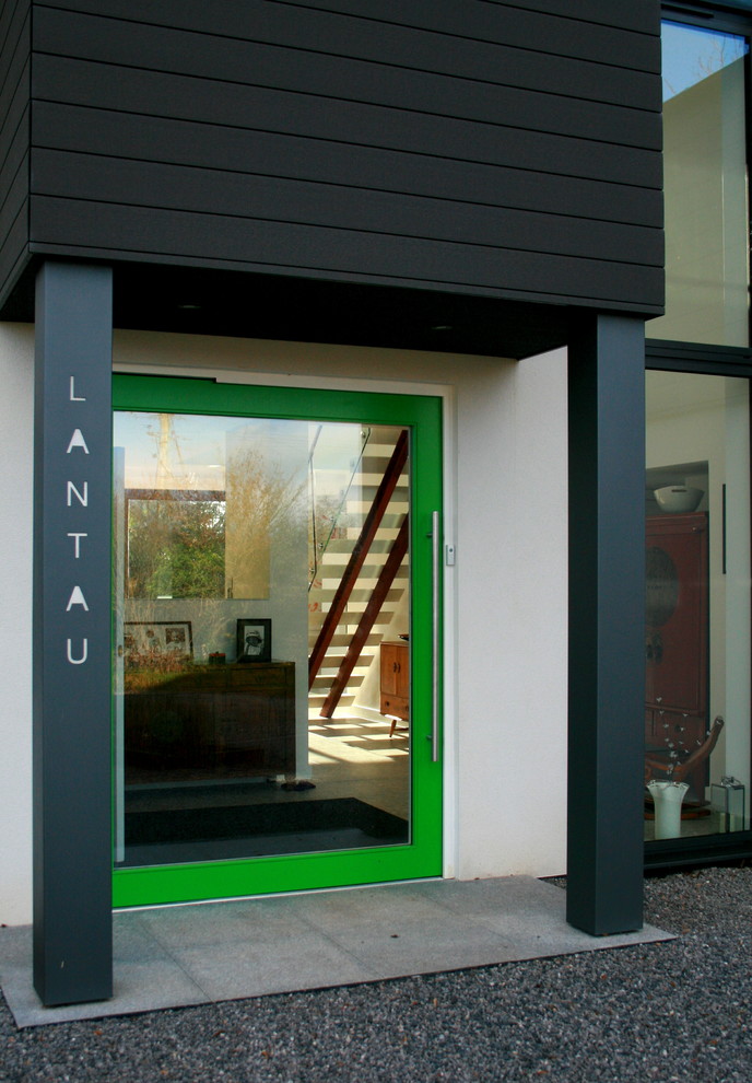 Esempio di una grande porta d'ingresso minimal con pareti bianche, pavimento in gres porcellanato, una porta a pivot e una porta verde