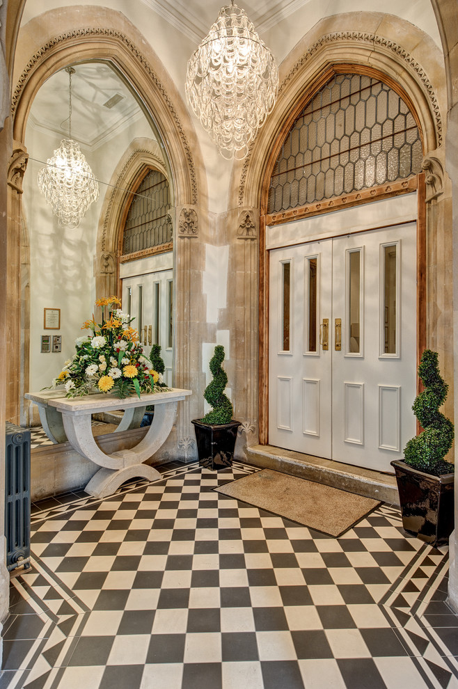 Huge ornate ceramic tile entryway photo in Devon with a white front door