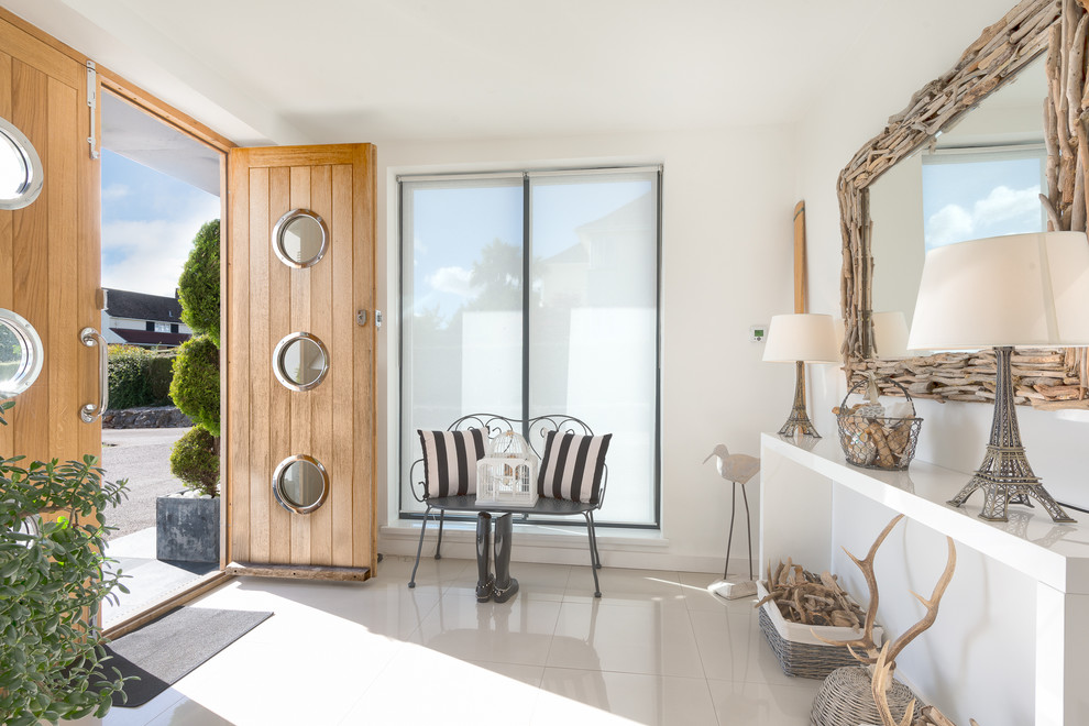 На фото: фойе среднего размера в морском стиле с белыми стенами, полом из керамической плитки, двустворчатой входной дверью и входной дверью из дерева среднего тона с