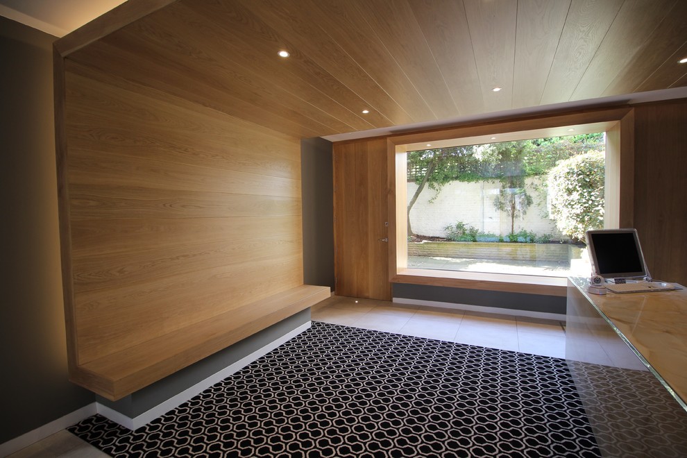 Cette image montre un vestibule design de taille moyenne avec un mur gris, moquette, une porte double, une porte métallisée et un sol multicolore.