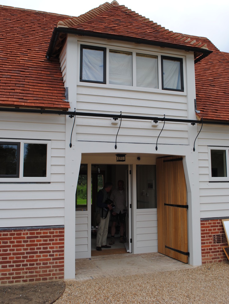 Photo of a large classic vestibule in Hertfordshire with white walls, brick flooring, a single front door, a white front door and brown floors.