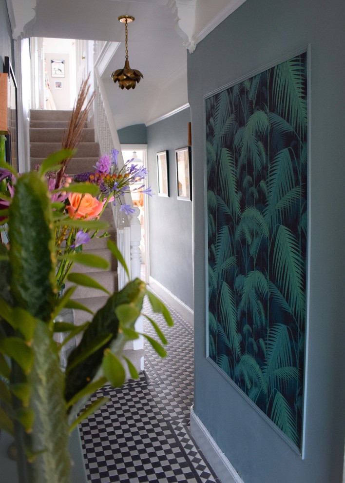 Idee per un piccolo corridoio boho chic con pareti blu, pavimento con piastrelle in ceramica e pavimento nero