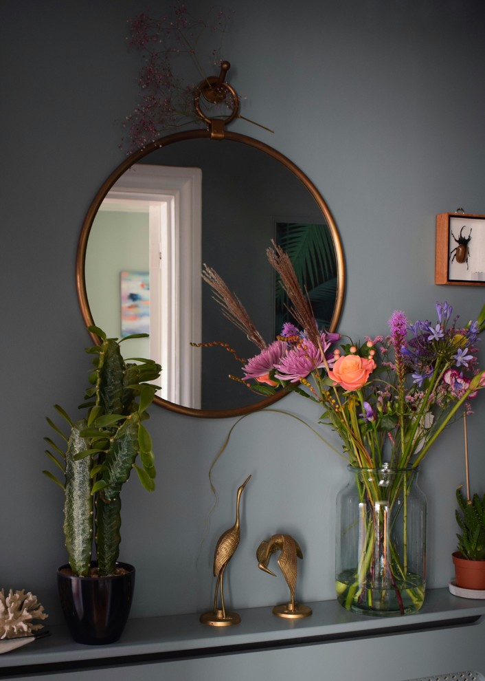 This is an example of a small bohemian hallway in Other with blue walls, ceramic flooring and black floors.