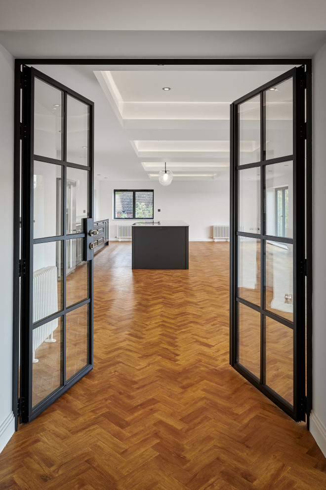 Photo of a medium sized modern hallway in Surrey with white walls and medium hardwood flooring.