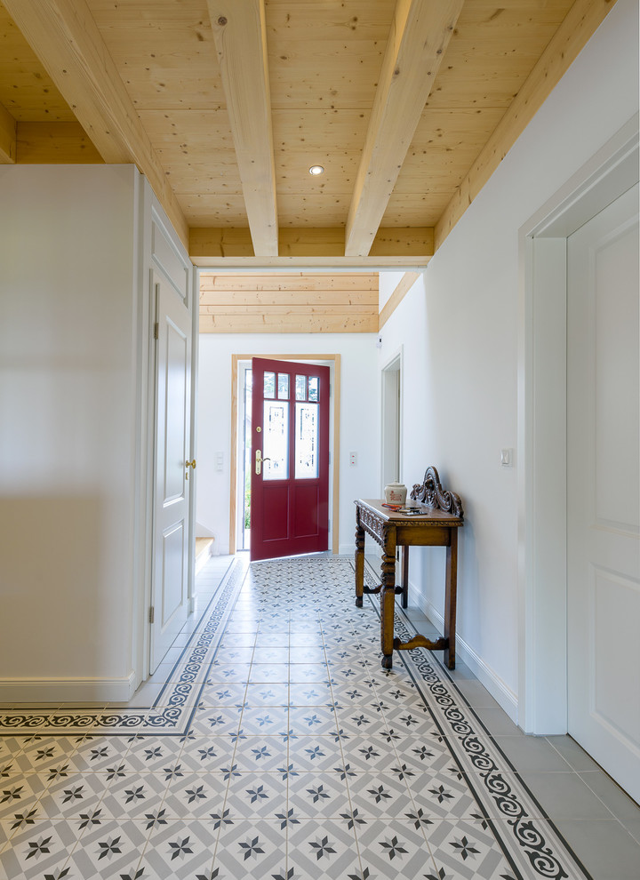 Стильный дизайн: входная дверь среднего размера в стиле кантри с белыми стенами, полом из керамической плитки, одностворчатой входной дверью, красной входной дверью и разноцветным полом - последний тренд