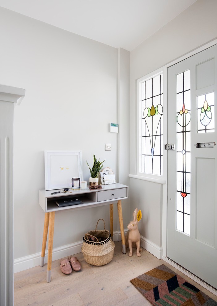 Modelo de distribuidor nórdico con paredes grises, suelo de madera clara, puerta simple, puerta de vidrio y suelo beige