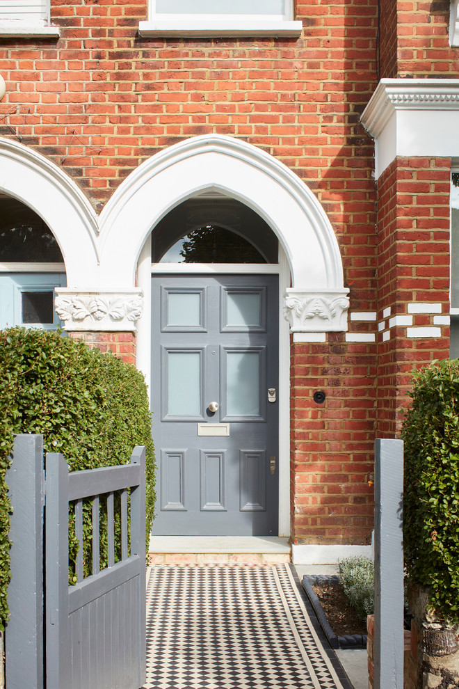 Ejemplo de puerta principal clásica grande con puerta simple, puerta gris, suelo de baldosas de porcelana, suelo multicolor y ladrillo