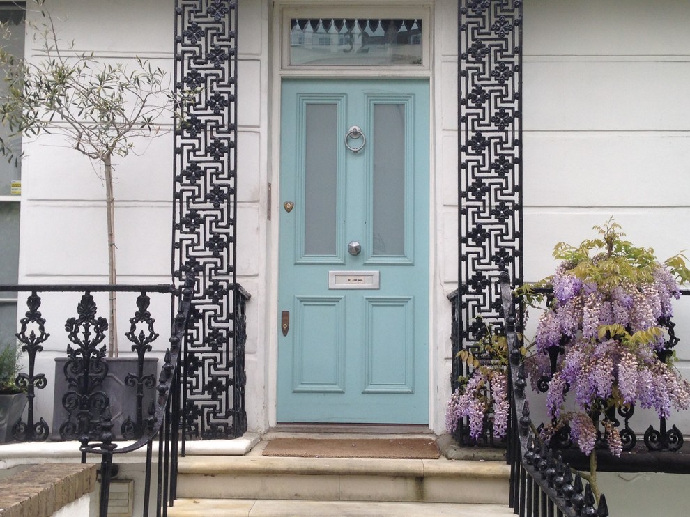 Imagen de puerta principal minimalista grande con paredes blancas, suelo de piedra caliza, puerta simple y puerta azul