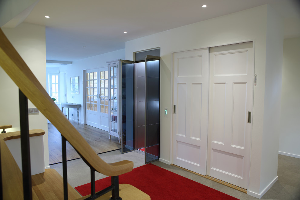 Idee per un piccolo corridoio design con pareti marroni, moquette e pavimento rosso