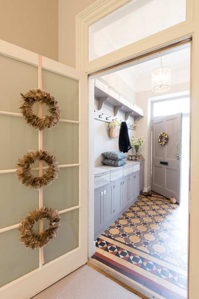 エディンバラにあるお手頃価格の小さなトランジショナルスタイルのおしゃれな玄関ラウンジ (ベージュの壁、セラミックタイルの床、グレーのドア、マルチカラーの床) の写真