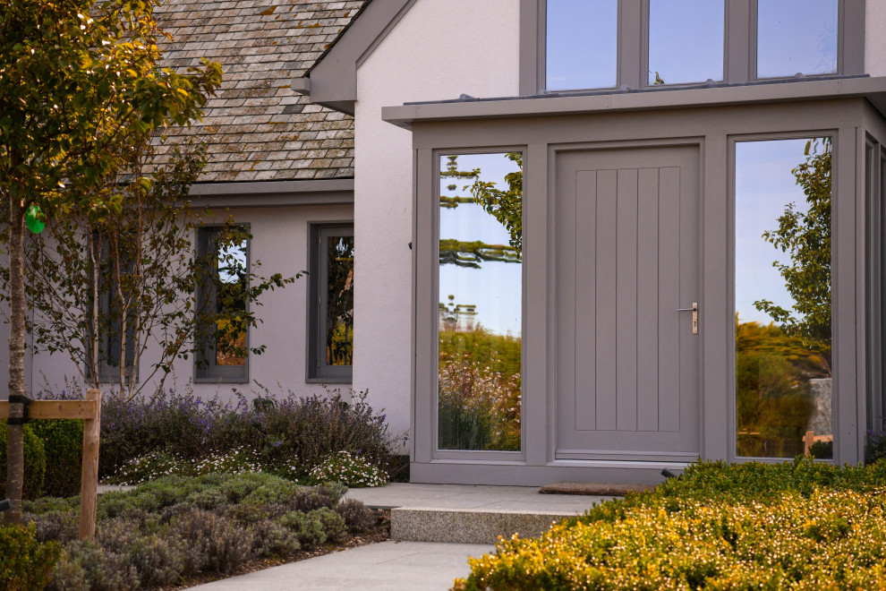 Ispirazione per una porta d'ingresso stile marinaro di medie dimensioni con pavimento in granito, una porta singola, una porta grigia e pavimento grigio