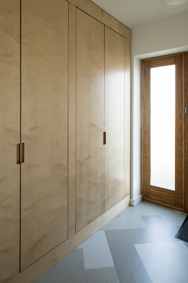 Réalisation d'un vestibule design de taille moyenne avec un mur blanc, un sol en linoléum, une porte simple et une porte en bois clair.