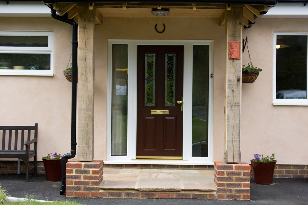 This is an example of a contemporary entrance in Kent with a brown front door.