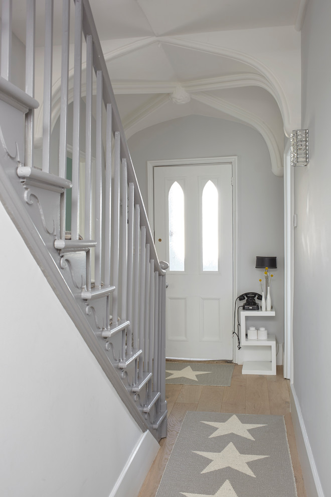 Inspiration for a medium sized contemporary hallway in London with grey walls, light hardwood flooring, a single front door and beige floors.