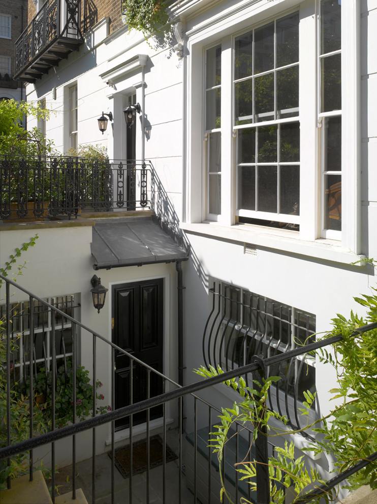 Источник вдохновения для домашнего уюта: входная дверь среднего размера в классическом стиле с белыми стенами, полом из известняка, одностворчатой входной дверью, черной входной дверью и зеленым полом