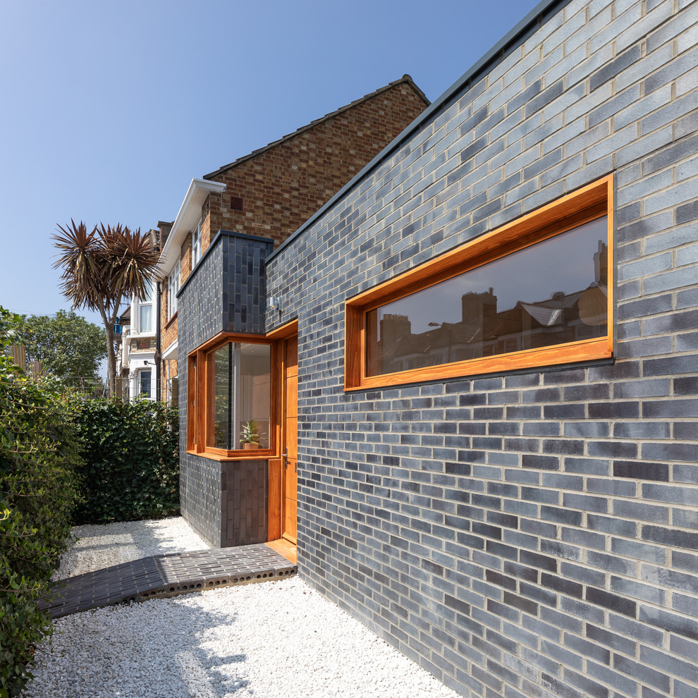 Entryway - mid-sized contemporary brick floor and gray floor entryway idea in London with gray walls and a medium wood front door