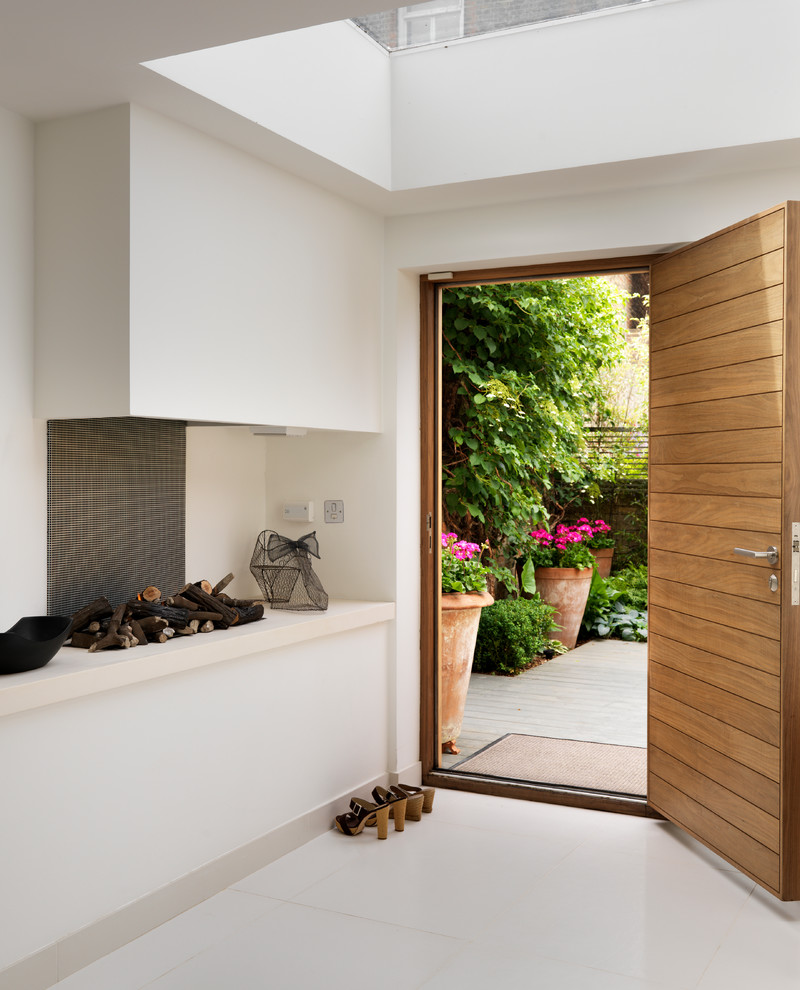 Idee per un corridoio design con pareti bianche, una porta singola, una porta in legno bruno e pavimento bianco