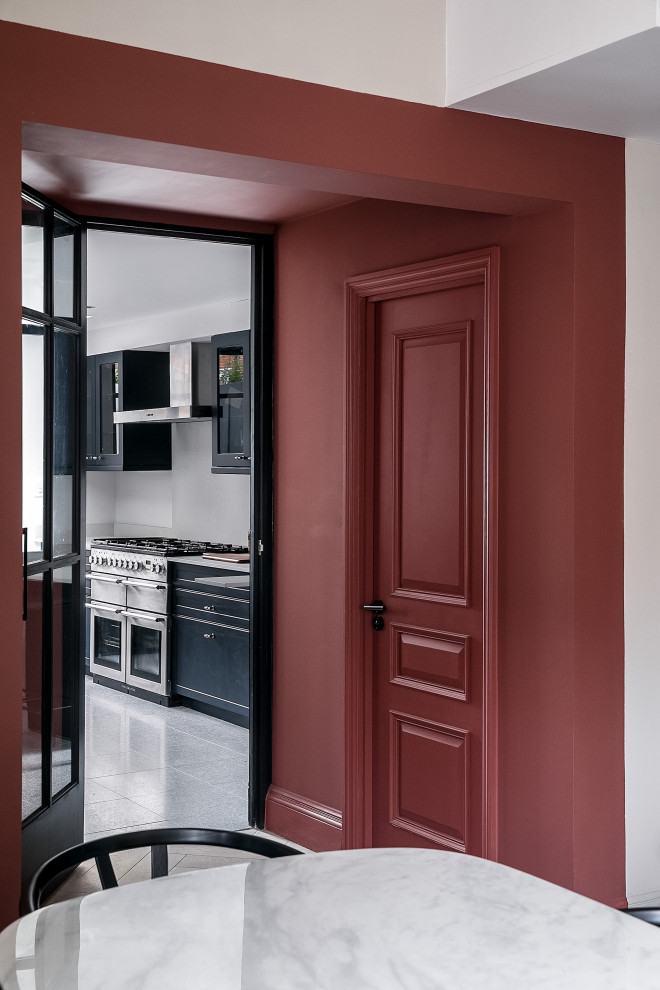 Aménagement d'une entrée contemporaine de taille moyenne avec un couloir, un mur rouge, un sol en bois brun, une porte simple et une porte noire.
