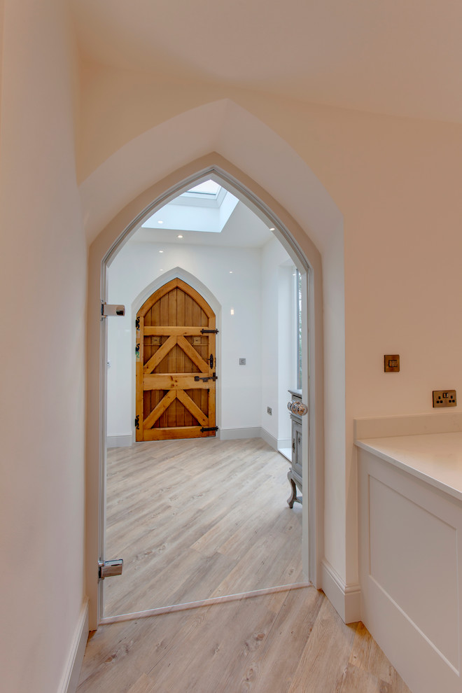 Idee per un ingresso con vestibolo chic di medie dimensioni con pareti bianche, parquet chiaro, una porta singola e una porta in legno bruno