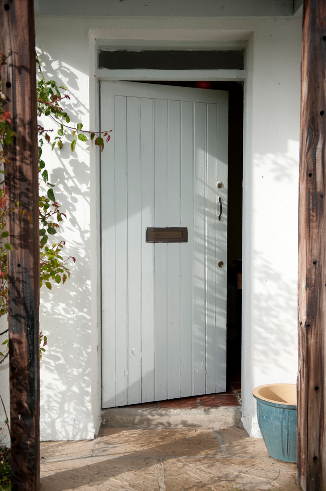 Idée de décoration pour une porte d'entrée chalet avec un mur blanc, une porte simple et une porte blanche.