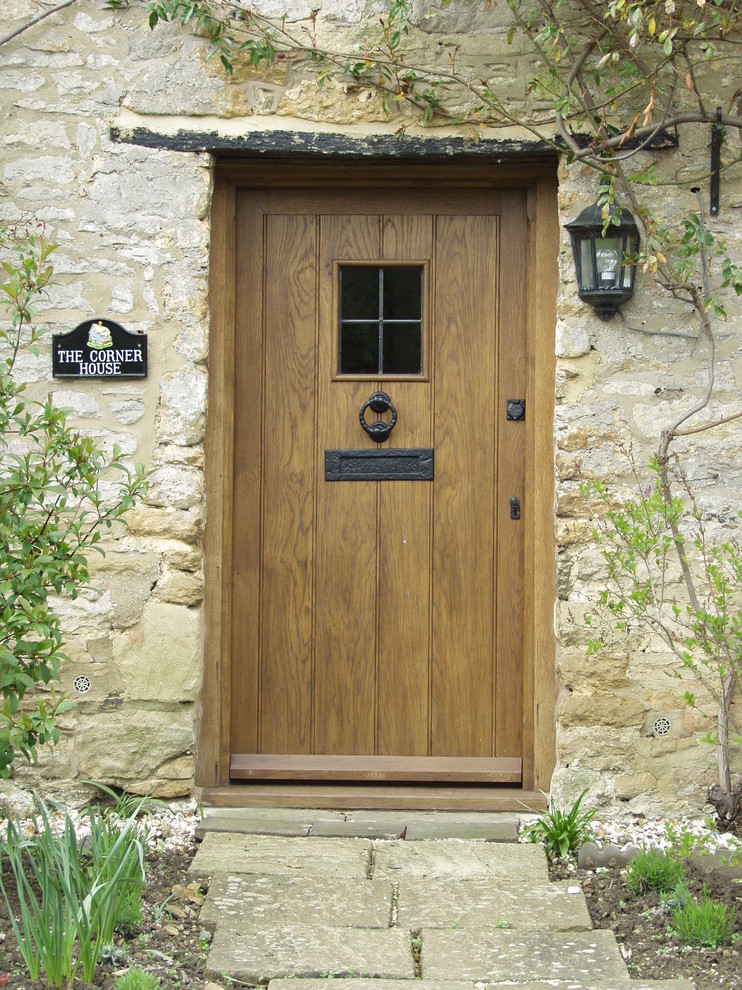 Aménagement d'une porte d'entrée campagne avec une porte simple et une porte en bois brun.