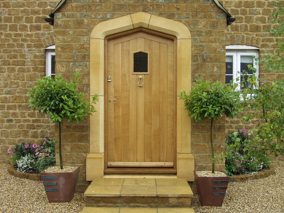 На фото: входная дверь в классическом стиле с одностворчатой входной дверью и входной дверью из дерева среднего тона с