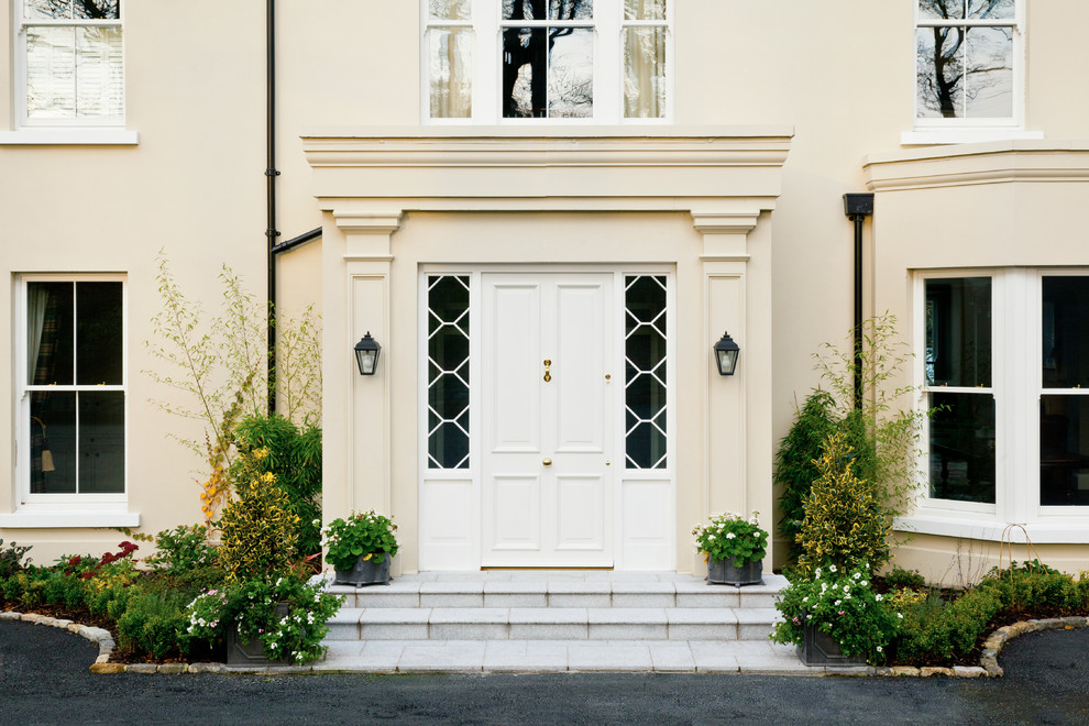 Klassisk inredning av en ingång och ytterdörr, med en vit dörr